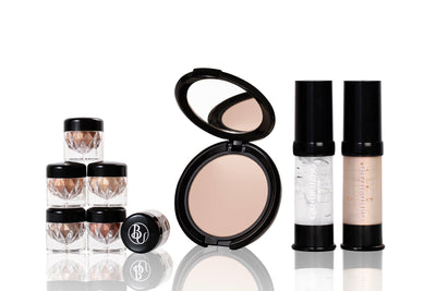 flat lay of makeup products surrounded by clear quartz crystals and makeup brushes.