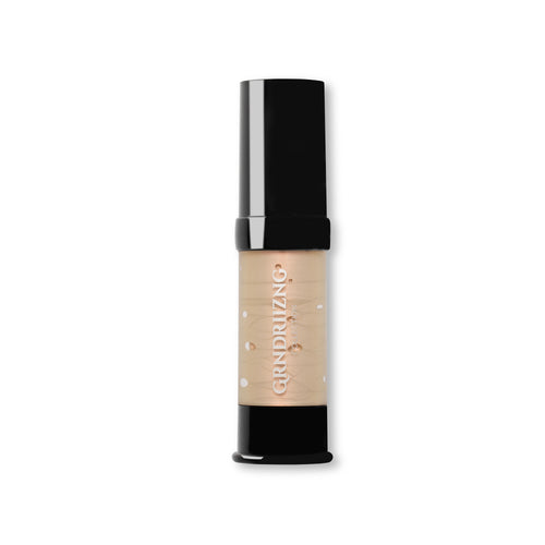 A single tube of GRNDRIIZNG makeup foundation with a black cap and a beige-toned body showing the liquid foundation inside, set against a plain white background.