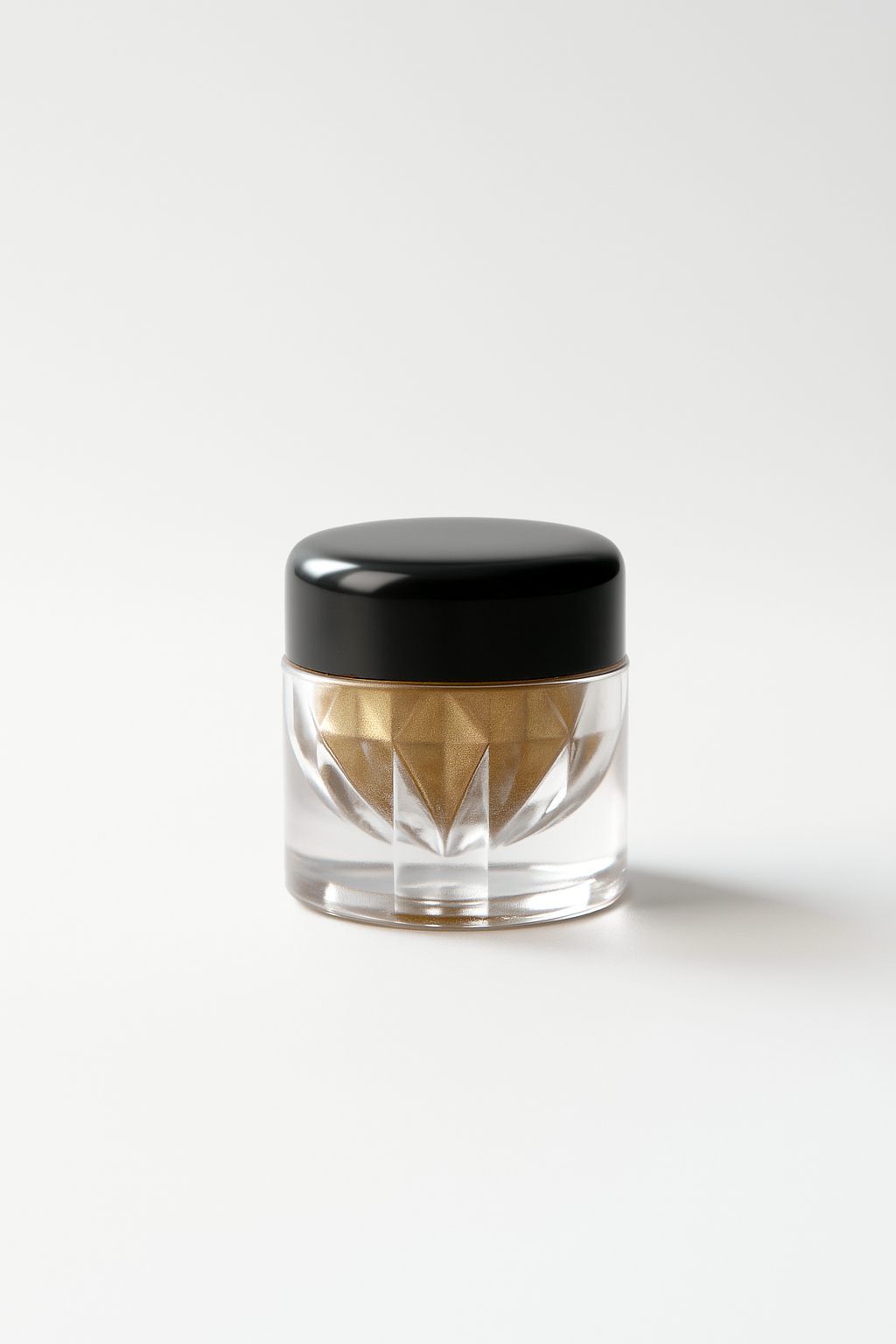 Clear jar with black lid containing a geometric-shaped object on a white background