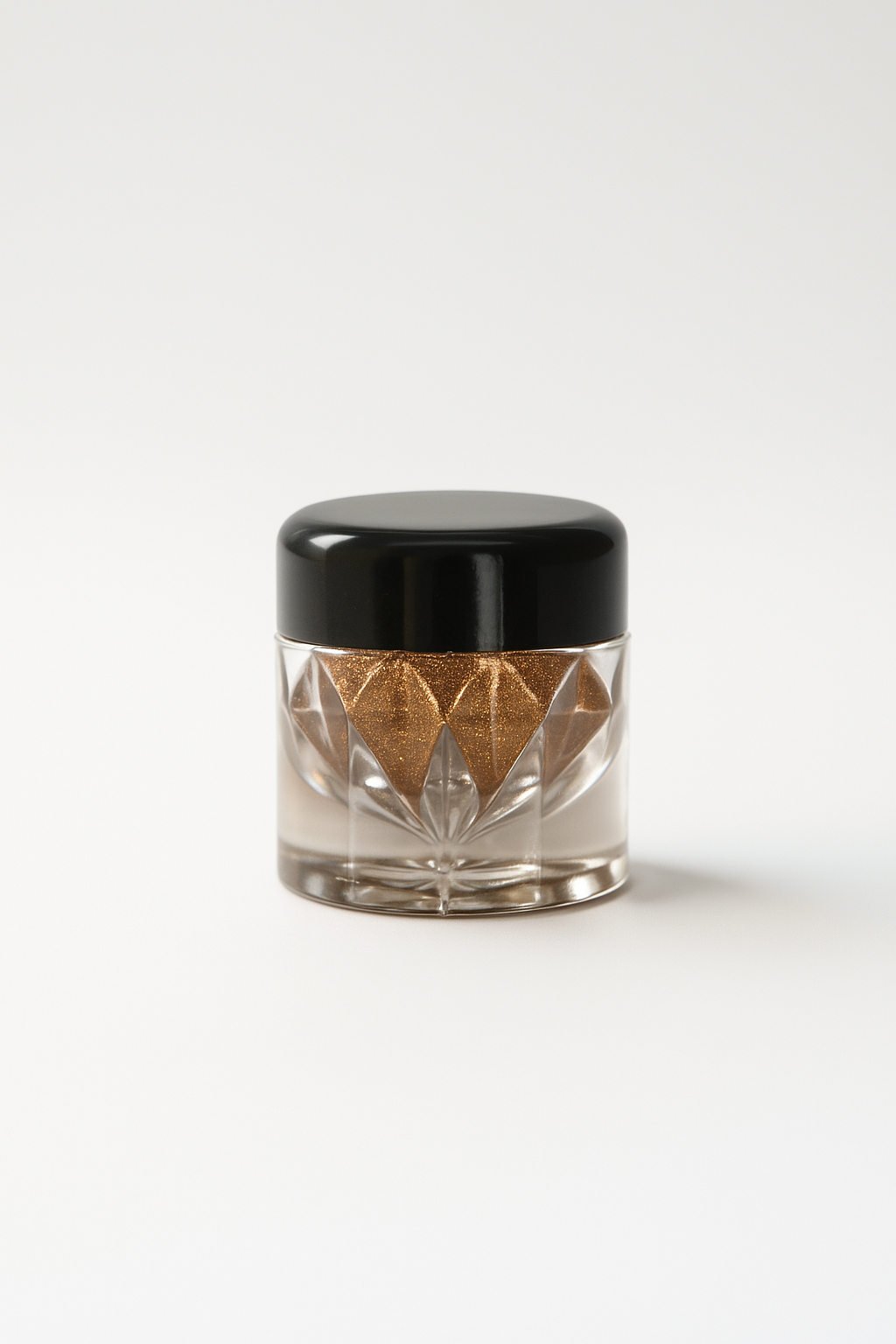 Small glass jar with black lid on a white background