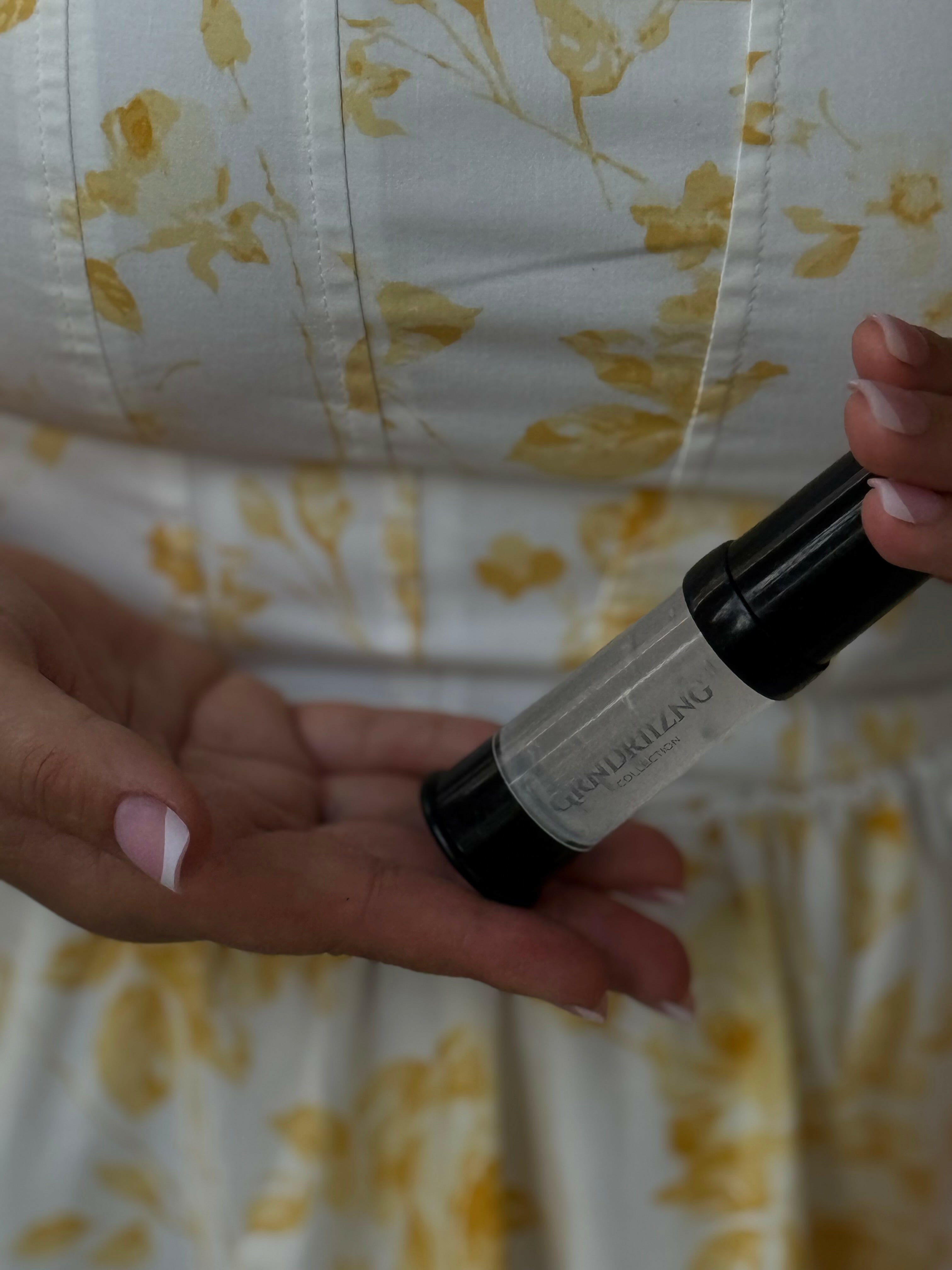 Hand holding a white and black pen with a floral-patterned background