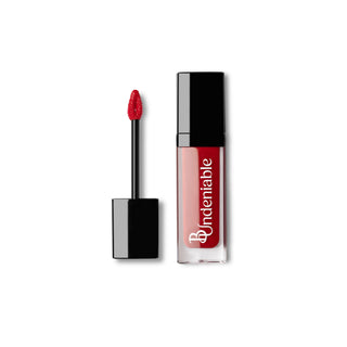 A liquid lipstick in a clear tube with a black cap, shown next to its applicator wand on a plain white background. The brand name 'B:Undeniable' is printed vertically in white on the tube.
