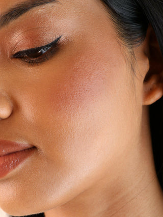 Close-up of a woman's face with makeup on her cheek and eyeshadow