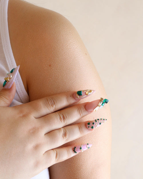 Close-up of a hand with decorated nails on a light background